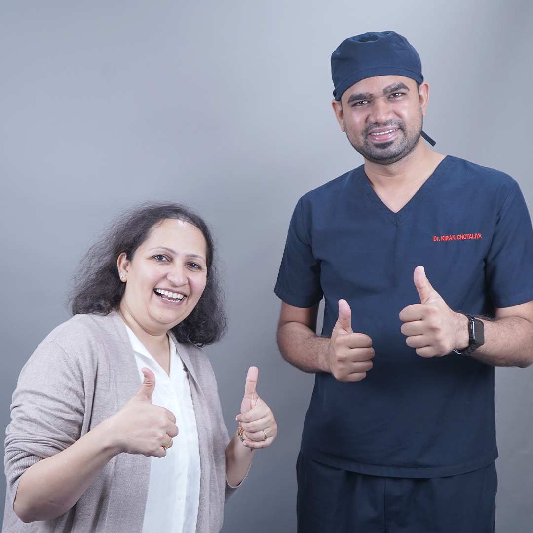 A happy female hair transplant patient smiling and giving a thumbs-up next to Dr. Kiran Chotaliya at our hair restoration clinic in Pune.